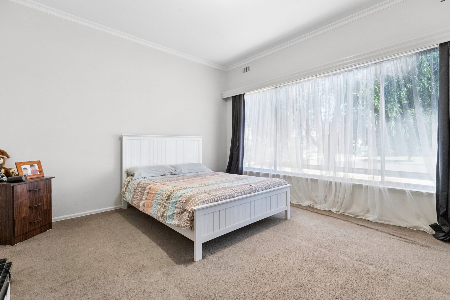 Light-filled main bedroom with a broad front window