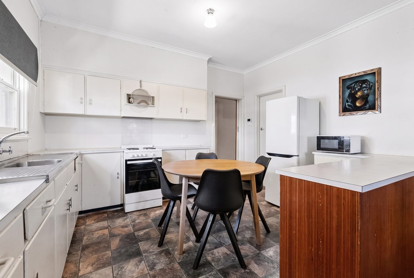 Retro-style kitchen with white cabinetry and adjoining dining space